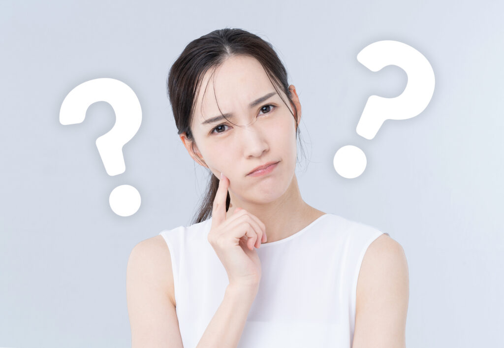 首を傾げて？を思い浮かべている女性