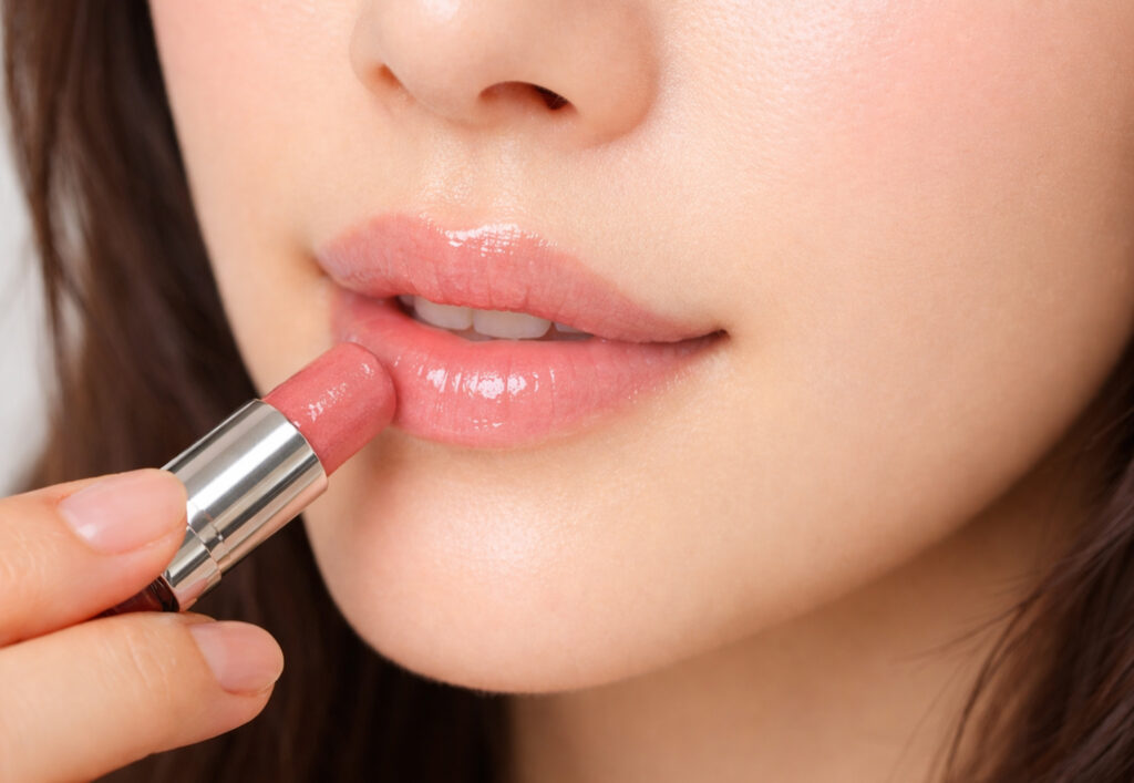 コーラル系のリップを塗っている女性